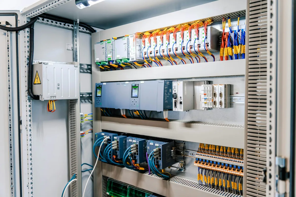 Geopende industriële besturingskast met bedrading en modules